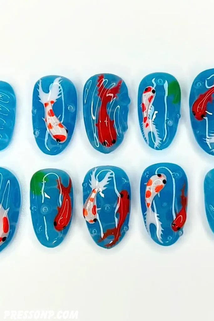 A close-up of almond-shaped nails featuring a milky, semi-translucent base decorated with delicate, hand-painted orange and white koi fish swimming amidst soft blue water ripples.