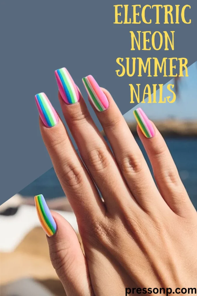 A hand showcasing "Electric Neon Summer Nails That Scream Fun" against a sunny beach background. The long, coffin-shaped nails feature a vibrant vertical stripe design with neon pink, electric blue, lime green, and sunny yellow colors. The text "ELECTRIC NEON SUMMER NAILS" is displayed in bold yellow font at the top right, emphasizing a trendy and bright vacation-ready look.