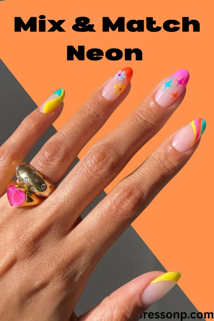 A hand featuring "Mix & Match Neon Summer Nails – No Rules" on almond-shaped nails with a sheer nude base. Each nail displays a unique neon design: yellow and teal abstract swirls, orange tips with dainty flowers, pink and teal starbursts, and multi-colored rainbow waves. The hand is accessorized with chunky gold rings, including a pink heart-shaped stone, set against a vibrant orange and gray split-color background.