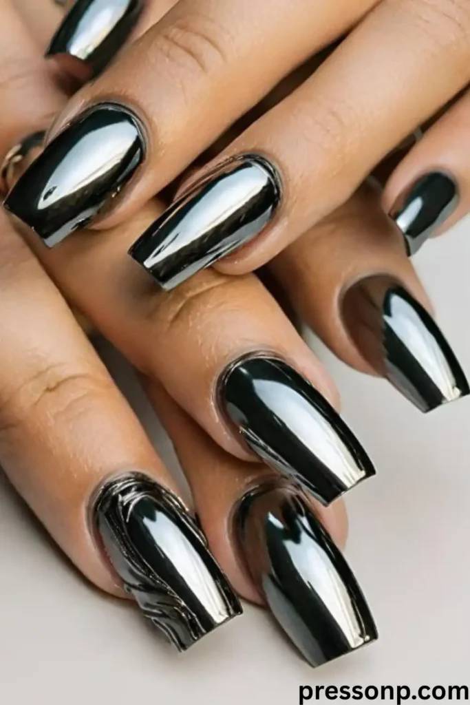 A close-up of a hand with medium-length, square-shaped nails painted in a luxurious, high-gloss champagne gold chrome polish that reflects light with a mirror-like finish