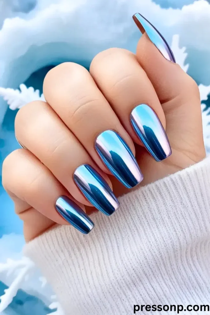 close-up of long, coffin-shaped nails featuring a striking, mirror-like ice blue chrome finish with purple and silver holographic reflections.
