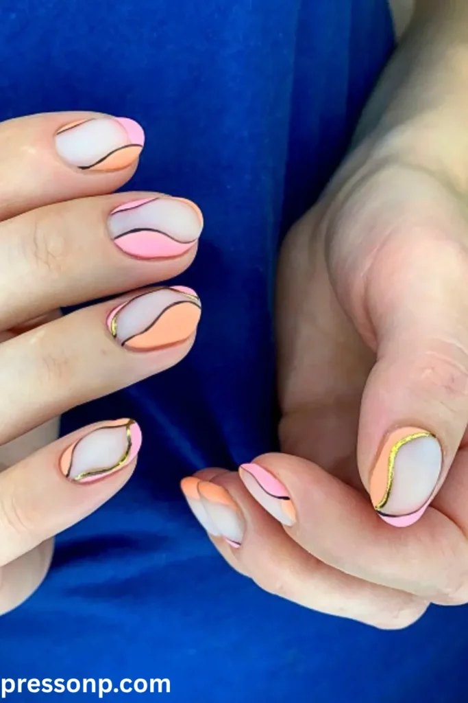 A close-up of short, oval nails featuring a matte lavender-white base decorated with glossy, abstract wavy blocks of pastel pink and peach outlined in black and metallic gold