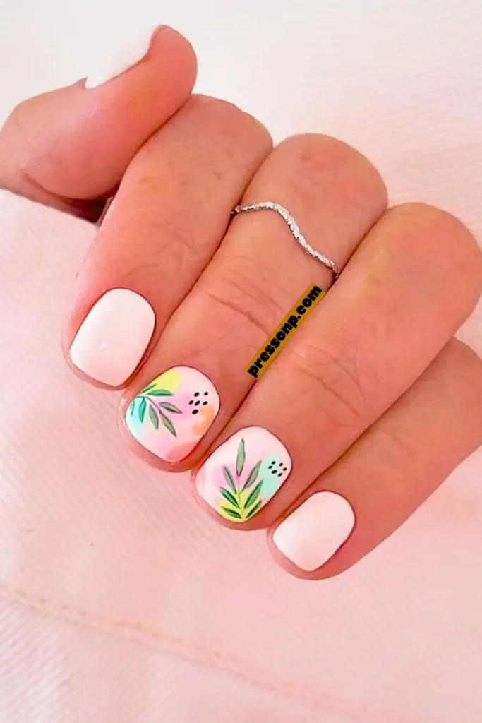 "A close-up of very short, squoval-shaped nails with less than a 2mm free edge. The manicure features solid white nails paired with two accent nails showing minimalist tropical botanical art: delicate green leaves, soft pink and orange watercolor washes, and tiny black dotted details. A yellow 'pressonp.com' watermark is placed vertically on the middle finger."