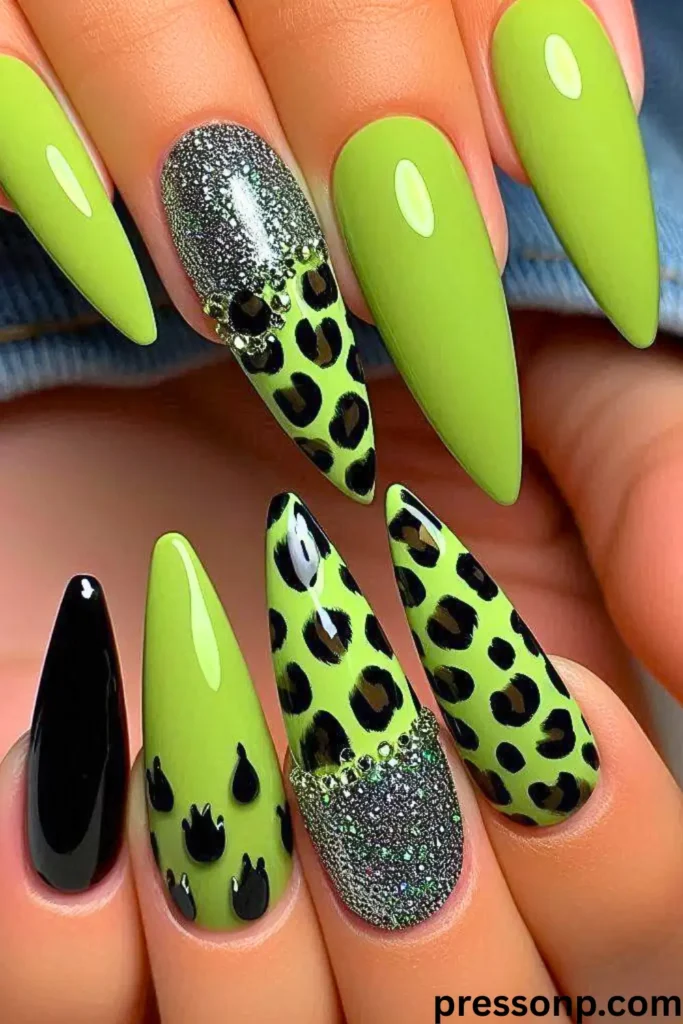 Long, stiletto-shaped nails featuring a mix of vibrant lime green, solid black, silver glitter, and bold leopard print patterns.