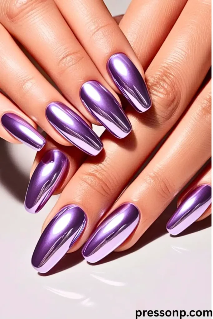 A close-up of two hands featuring long, almond-shaped nails with a high-shine metallic lavender chrome finish.