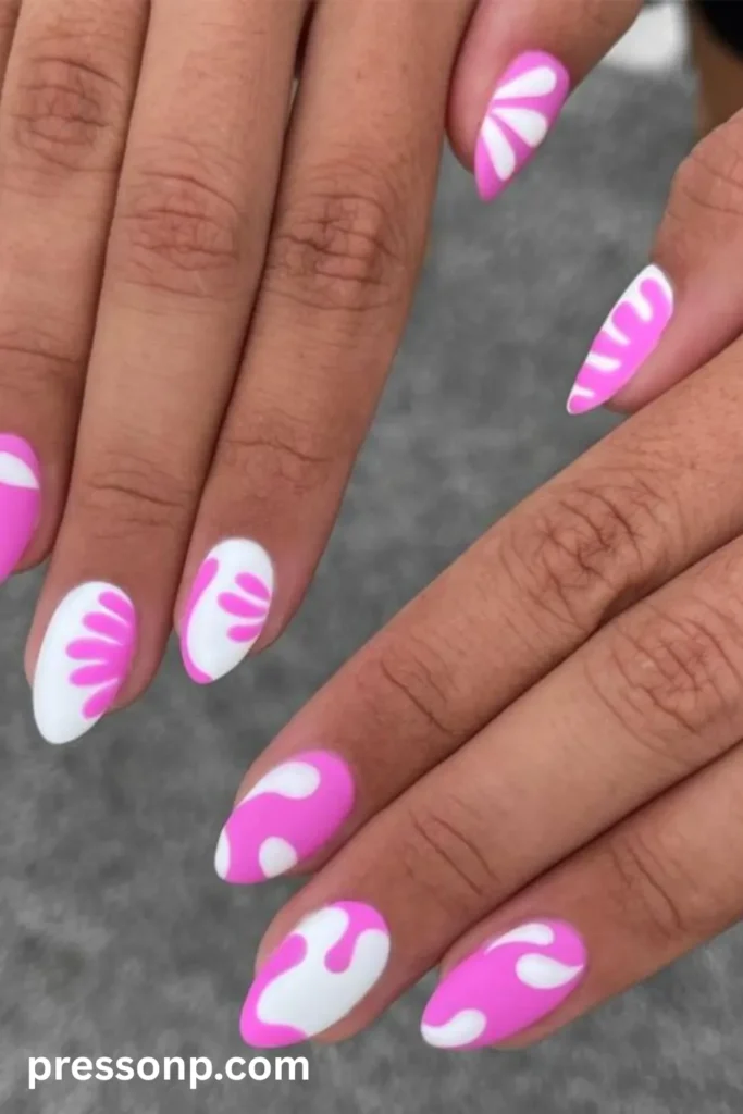 Close-up of long almond-shaped nails featuring a playful matte mix of bubblegum pink and white abstract retro flower petals and organic, wavy blob shapes.