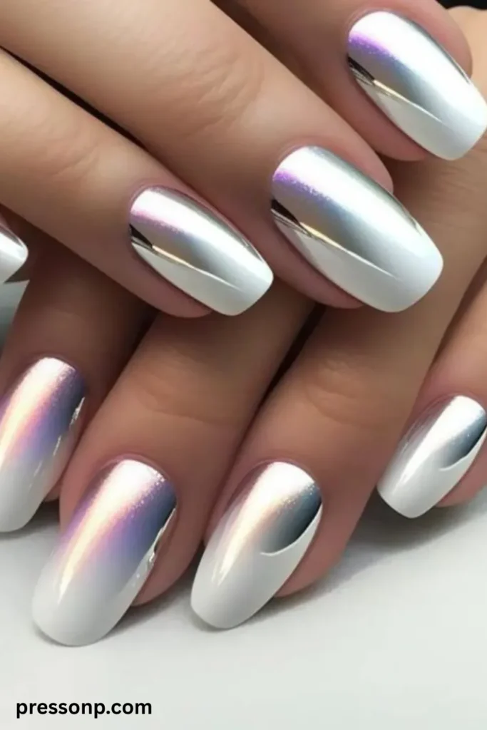 A close-up of two hands showing long squoval nails featuring a crisp white gel base blended with a liquid silver chrome gradient and an iridescent, pearlescent pink and purple shimmer reflection.