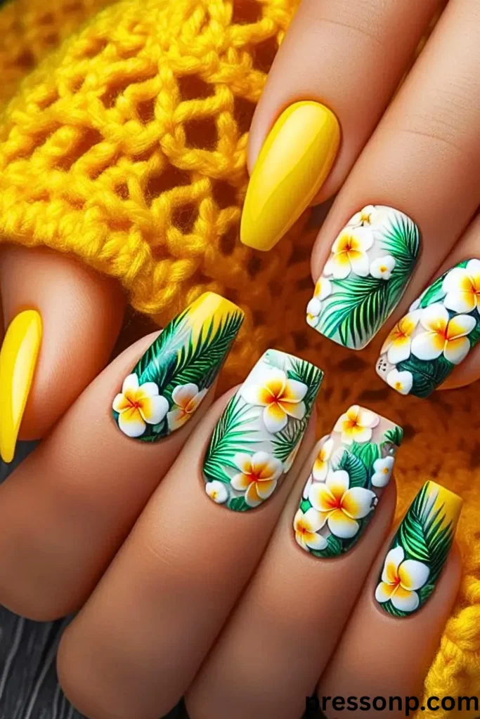 A close-up of hands displaying a high-gloss tropical manicure on medium coffin-shaped extensions, featuring solid bright yellow accent nails alongside white and yellow gradient canvases decorated with hand-painted plumeria flowers and deep green palm fronds.