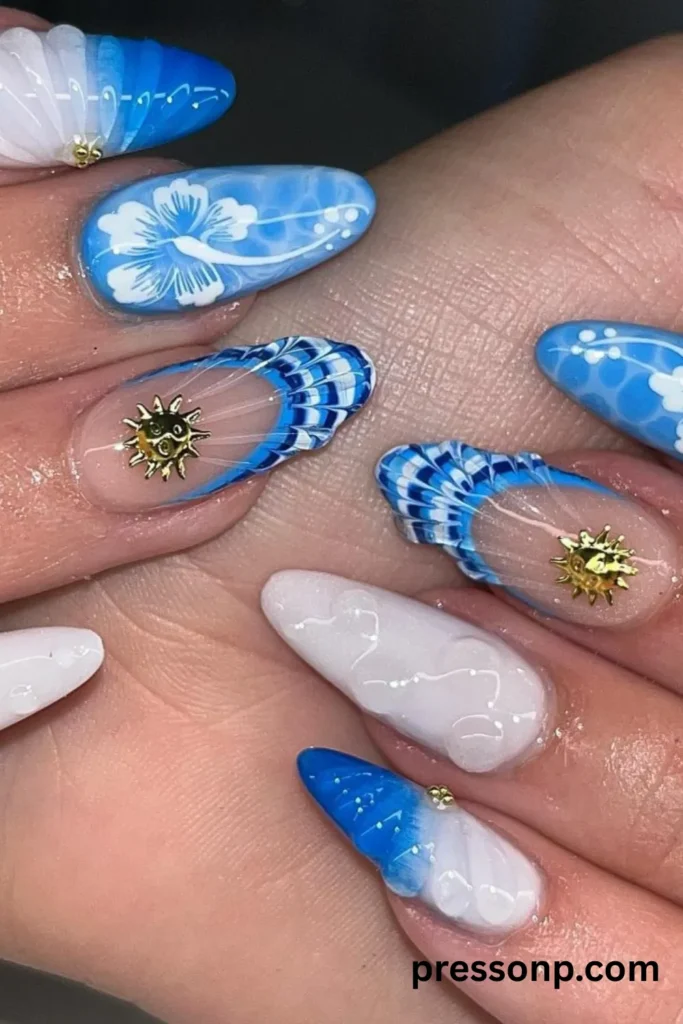 A close-up photograph of a detailed beach manicure on long almond nails, featuring an intricate mix of ocean blue water-ripple effects, a hand-painted white hibiscus flower, 3D textured seashells, and clear negative space frames accented with gold metallic sun charms.