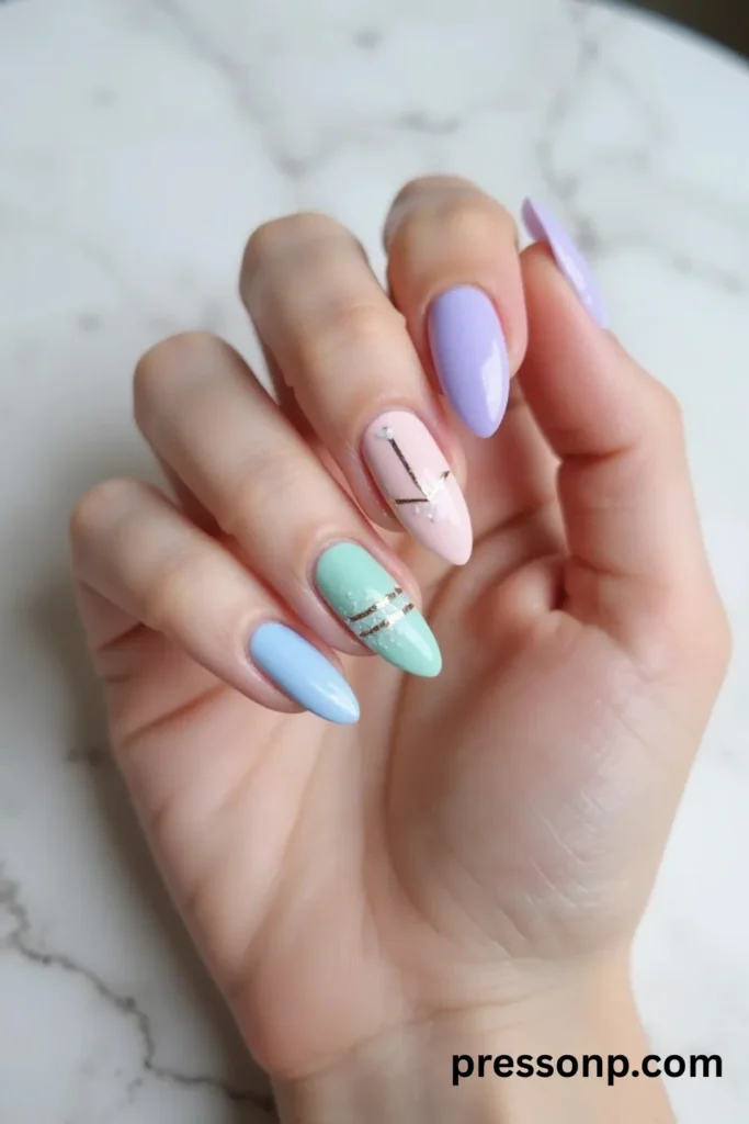 A close-up photograph of a detailed beach manicure on long almond nails, featuring an intricate mix of ocean blue water-ripple effects, a hand-painted white hibiscus flower, 3D textured seashells, and clear negative space frames accented with gold metallic sun charms.