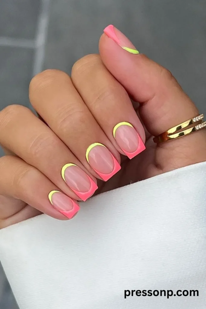 A close-up of medium-length, square-shaped manicured nails featuring vibrant neon pink French tips paired with a contrasting neon yellow outline tracing the cuticles.