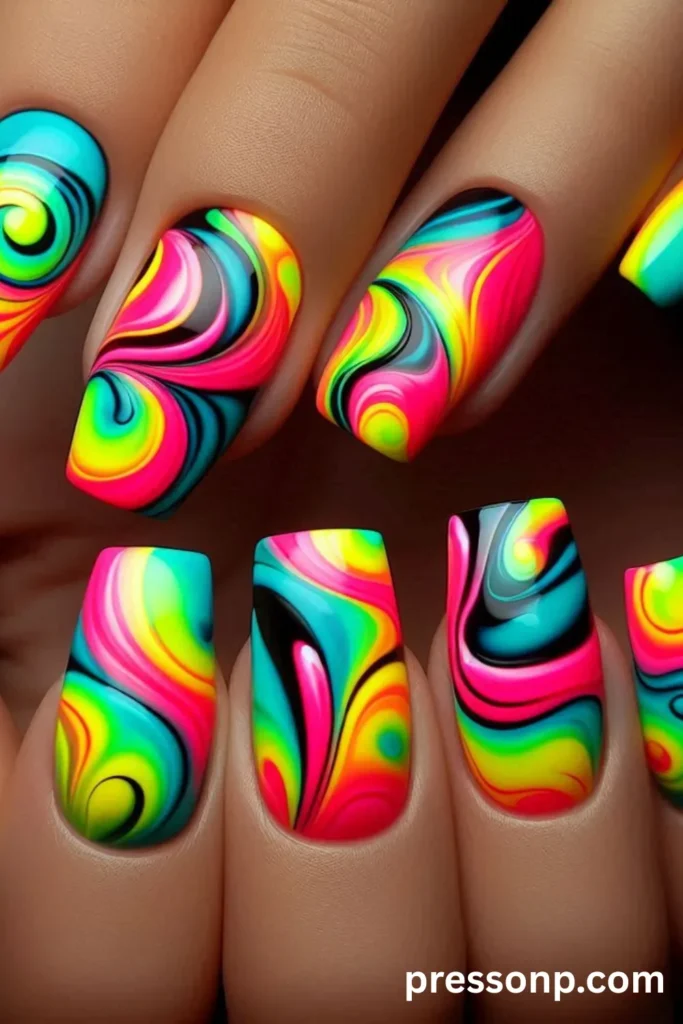 Close-up of long coffin-shaped acrylic nails featuring an ultra-glossy, psychedelic tie-dye swirl design in vibrant rainbow neon colors.