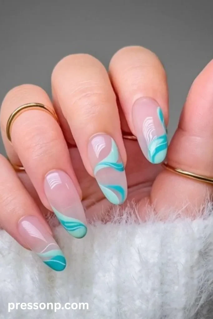 Close-up of long almond-shaped nails featuring a translucent nude base decorated with flowing abstract swirls in shades of turquoise, mint green, and fine white lines.