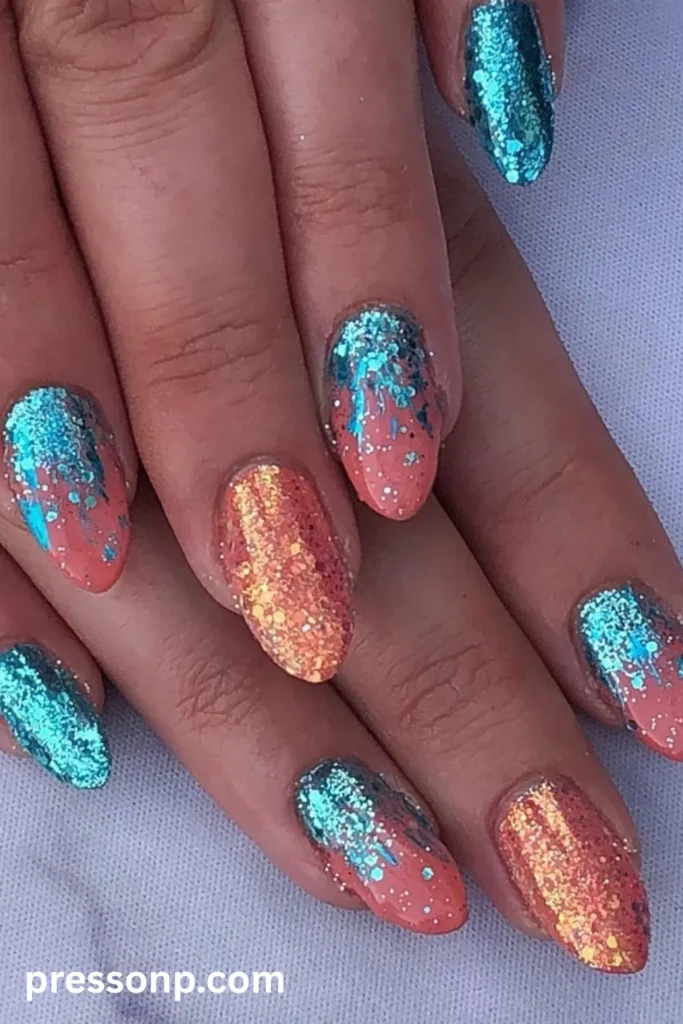 Close-up of almond-shaped nails featuring a vibrant coral base color blocked with chunky metallic turquoise glitter gradients and full-glitter accent nails