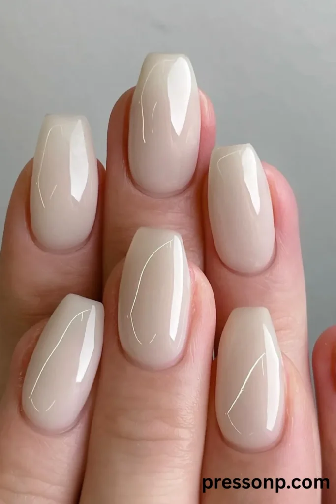 Close-up of medium coffin-shaped nails featuring a solid, semi-translucent milky white gel polish with a high-gloss finish.