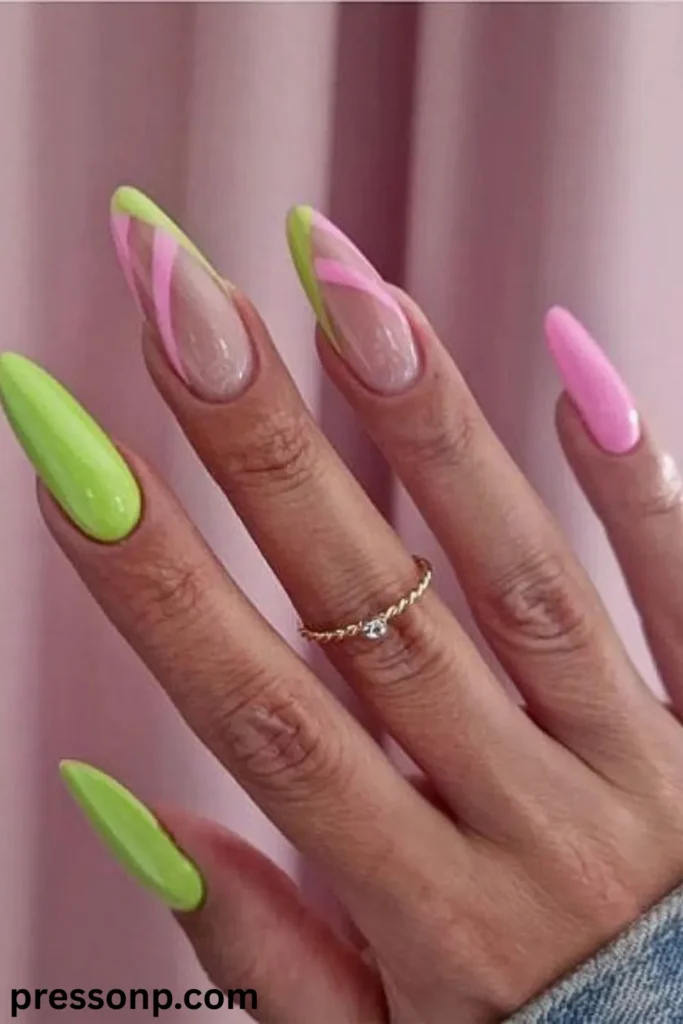 A close-up of a hand showcasing extra-long, high-gloss stiletto extensions featuring a mix of solid neon lime green and bubblegum pink lacquer alongside clear negative-space accent nails with intersecting chartreuse green and hot pink abstract swirl lines.
